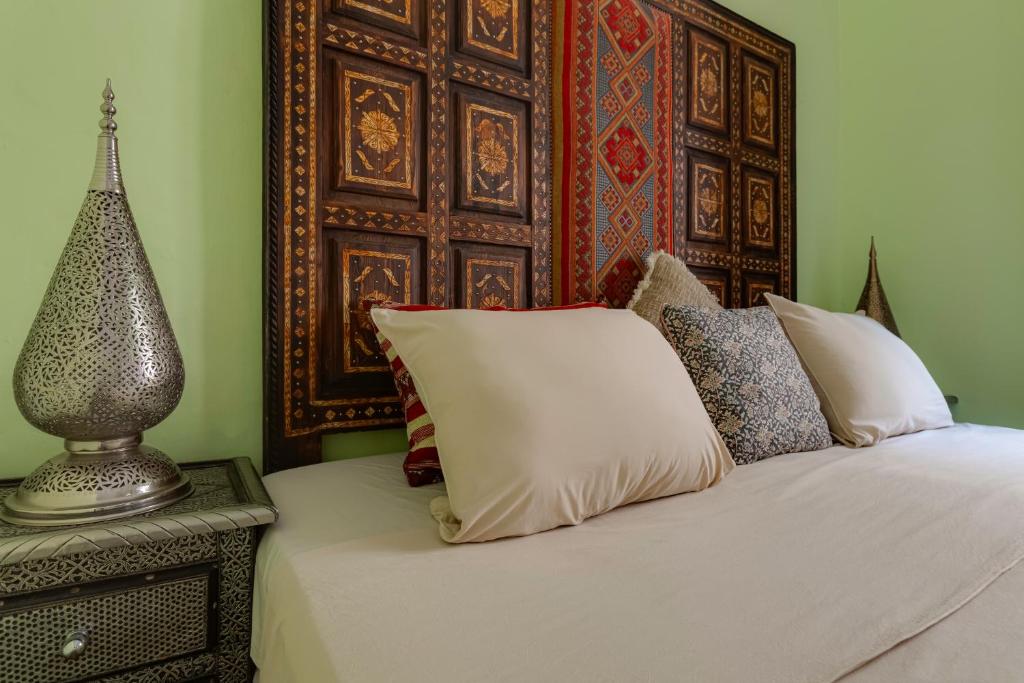 a bed with white sheets and pillows next to a wall at Casa da Moura in Lagos