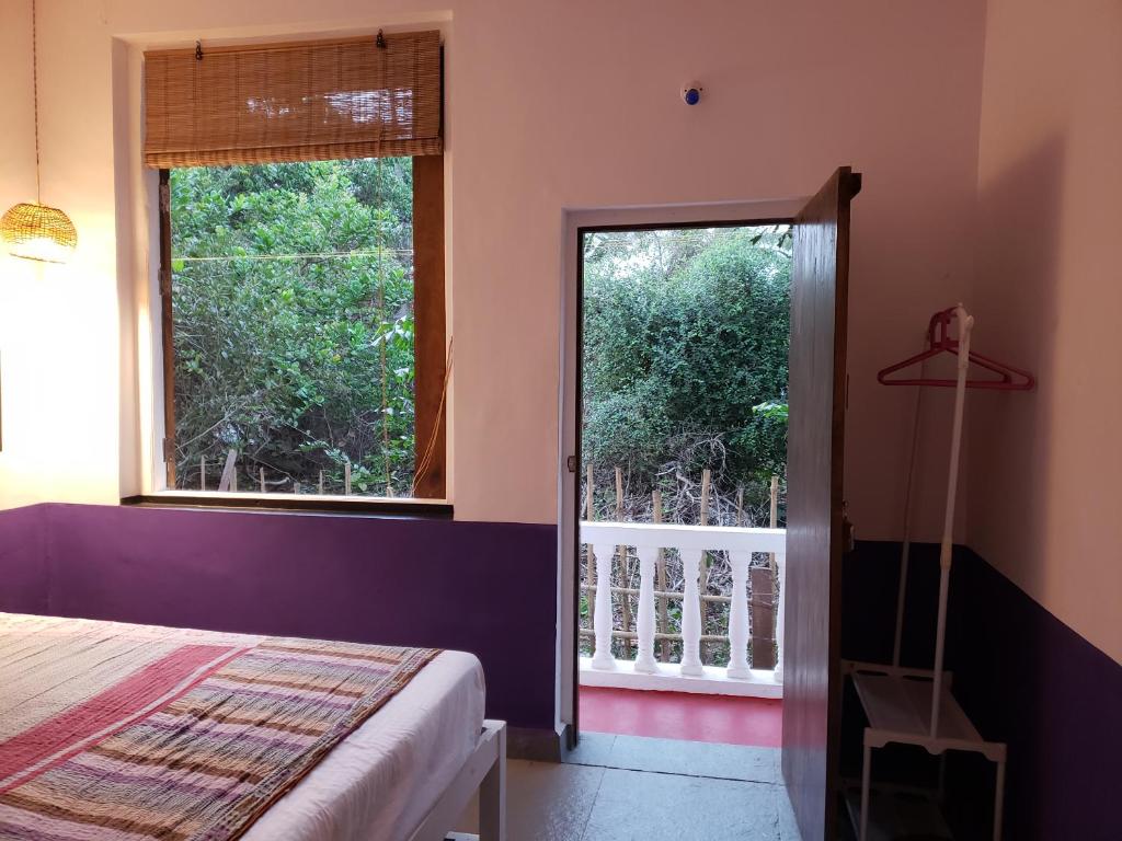 a bedroom with a bed and a large window at Laxmi Happy Home in Querim Goa in Querim