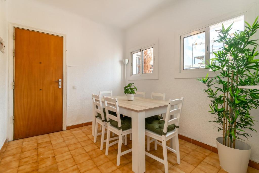 uma sala de jantar branca com uma mesa e cadeiras brancas em RONDA em Barcelona