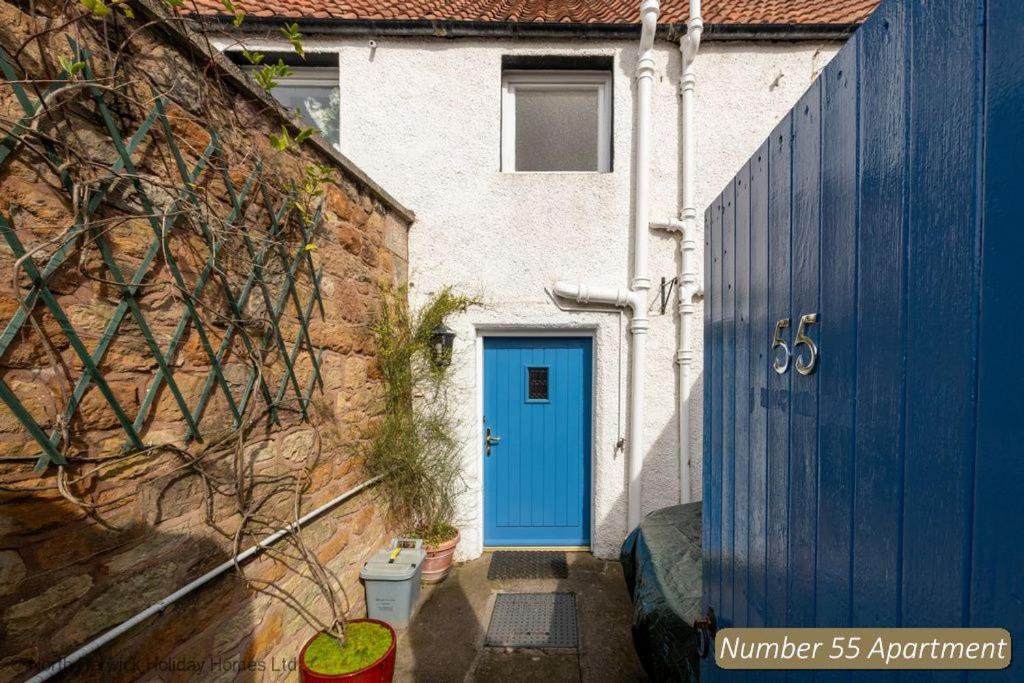 a blue door on a house with a brick wall at Number 55 Apartment in North Berwick