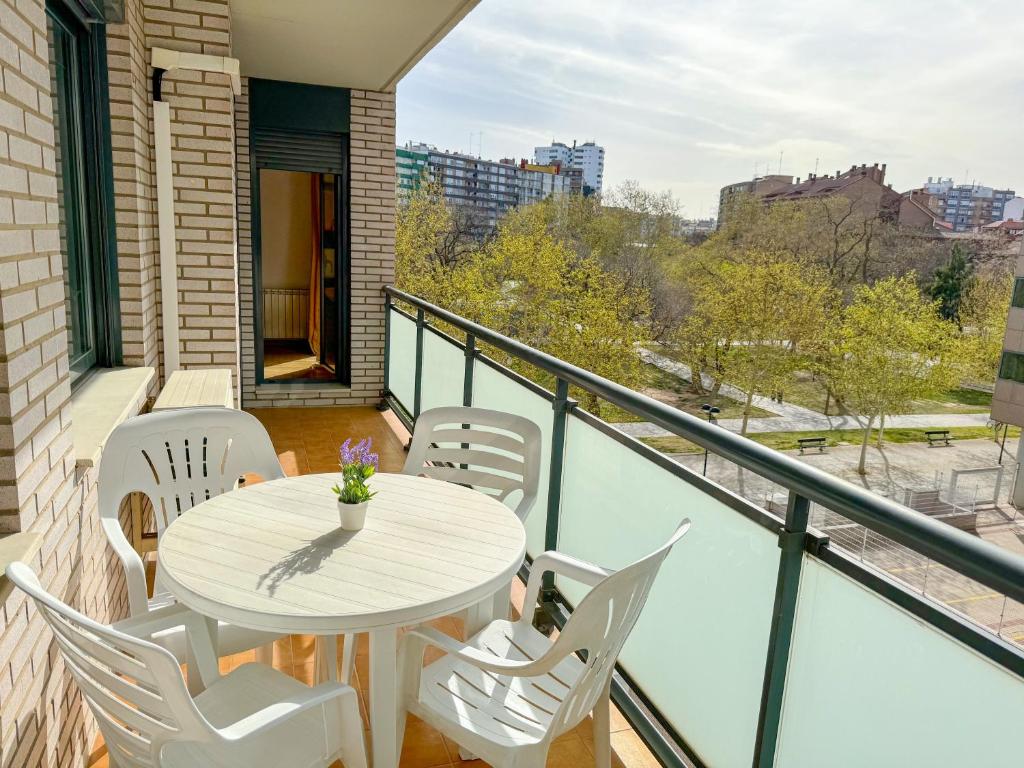 a white table and chairs on a balcony with a view at Reina del Pilar ComoTuCasa in Zaragoza