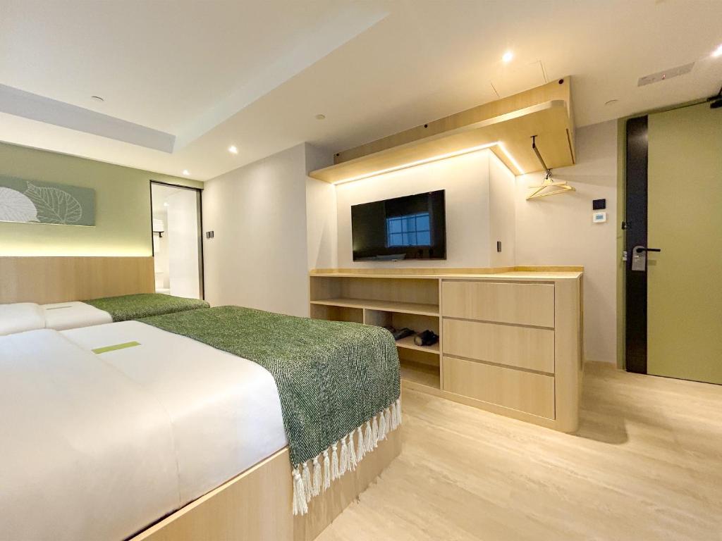 a bedroom with a bed and a flat screen tv at Urbanwood Hung Hom in Hong Kong