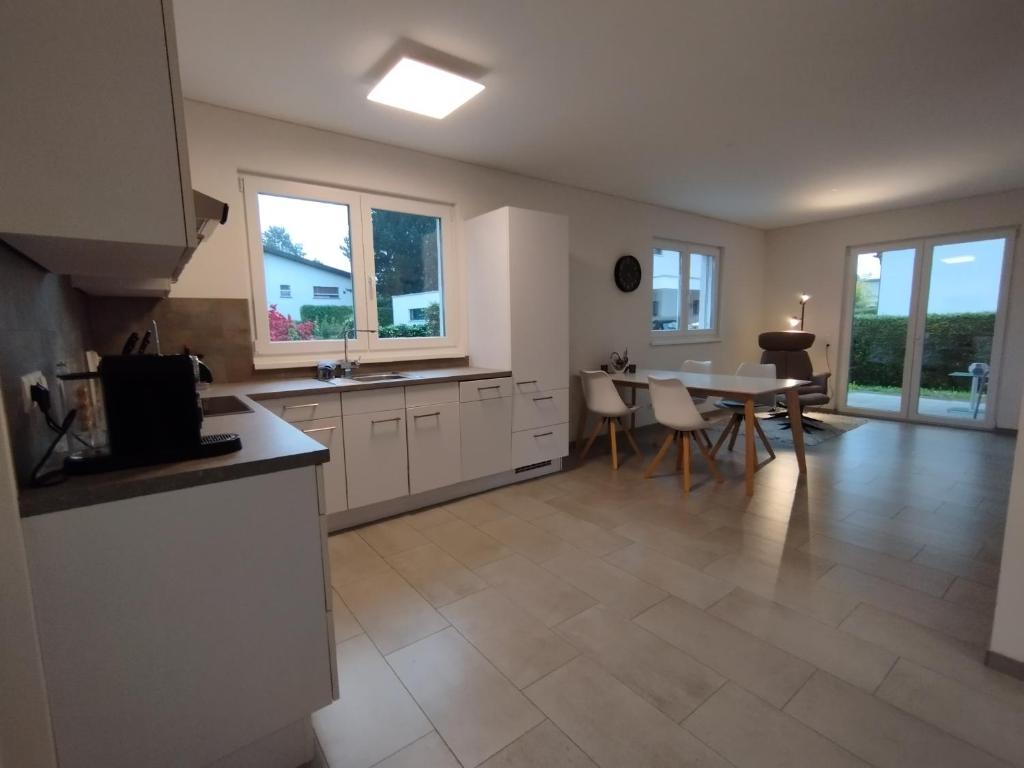 a kitchen and dining room with a table and chairs at CROWN LIVING Design Apartment - gratis Parkplatz - WLan - Küche - Self Check-in in Altach