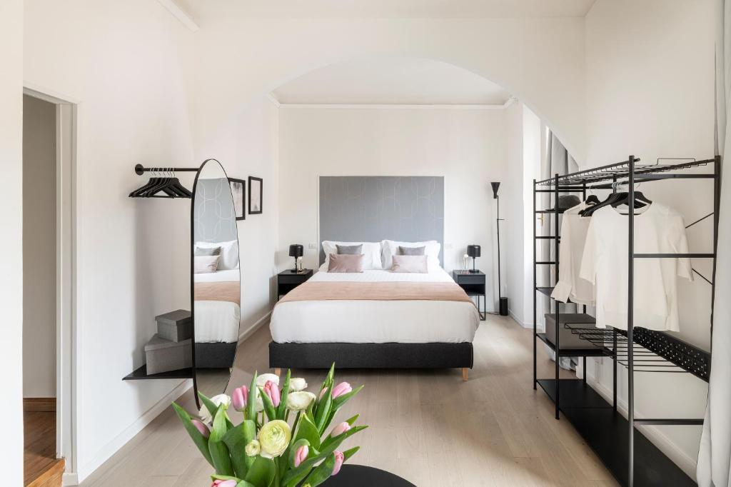 a white bedroom with a bed and a mirror at Easylife - Suite in Porta Venezia in Milan