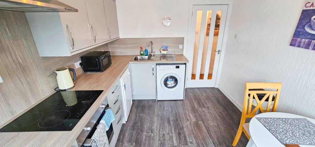 a small kitchen with a washing machine in it at Lovat 2 Bedroom Apartment - Inverness in Inverness