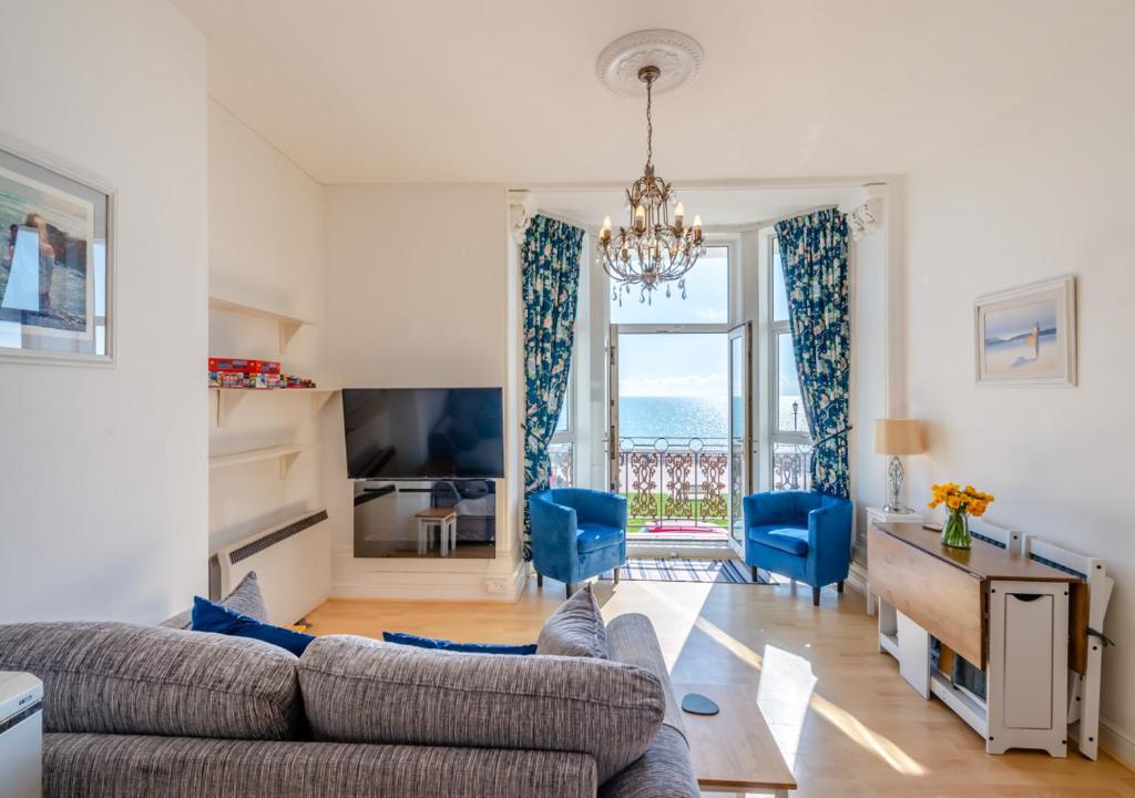 a living room with a couch and blue chairs at Coastal Nest - Hythe in Hythe
