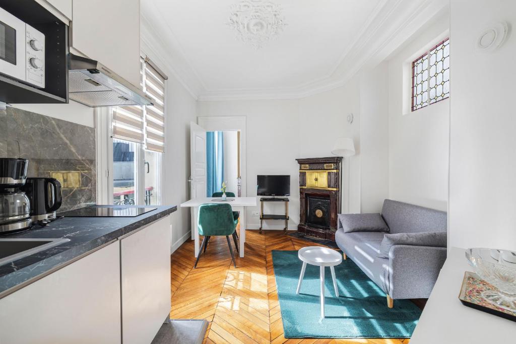 une cuisine et un salon avec un canapé et une table dans l'établissement Heimat, à Paris
