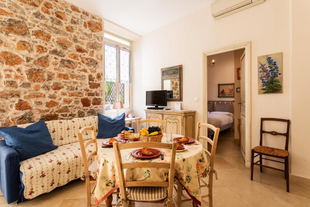 een woonkamer met een tafel en een bakstenen muur bij Frères Pradignac in Cannes