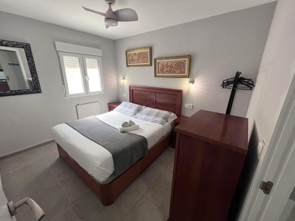 - une chambre avec un lit et une croix sur le mur dans l'établissement Apartamentos FULL EQUIPPED, à Elche