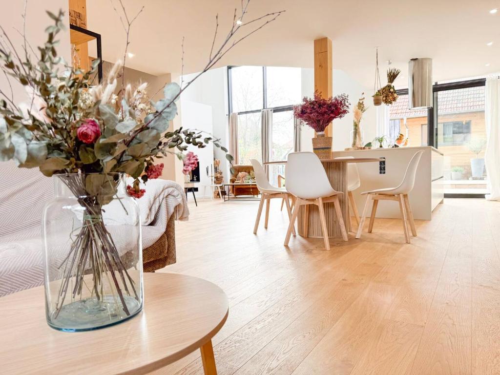 ein Wohnzimmer mit einer Blumenvase auf dem Tisch in der Unterkunft Penthouse *A la belle étoile* in Wahlbach