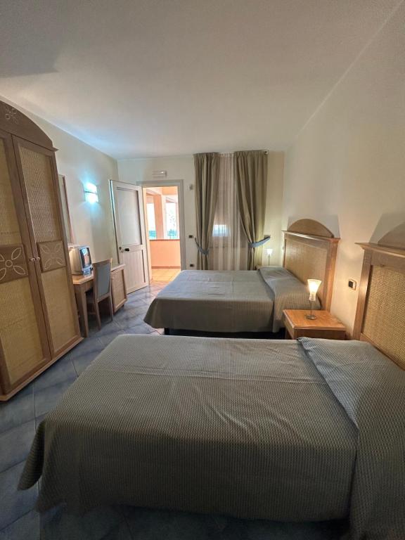 a hotel room with two beds and a table at Hotel le 3 lanterne in Marina di Sibari