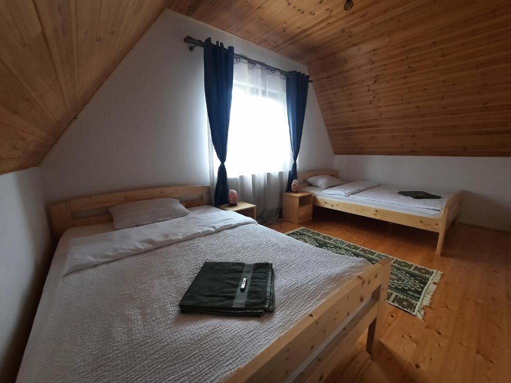 1 dormitorio con cama y ventana en Zöld Tulipán, en Praid