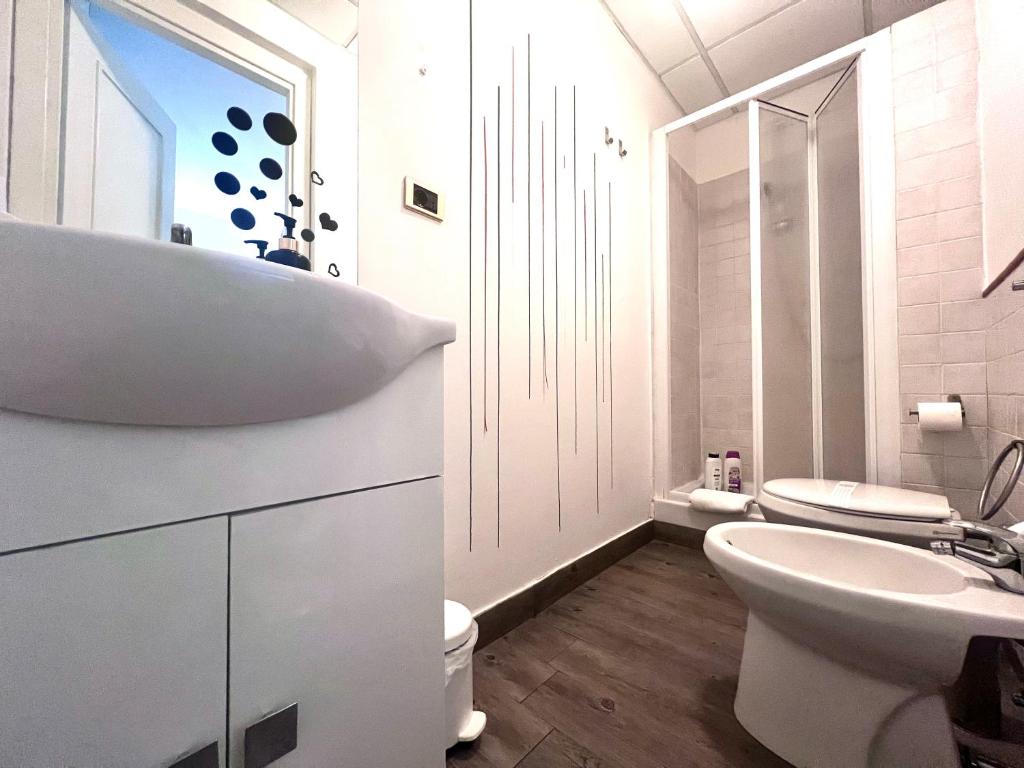 a white bathroom with a sink and a toilet at Mia House Roma in Rome