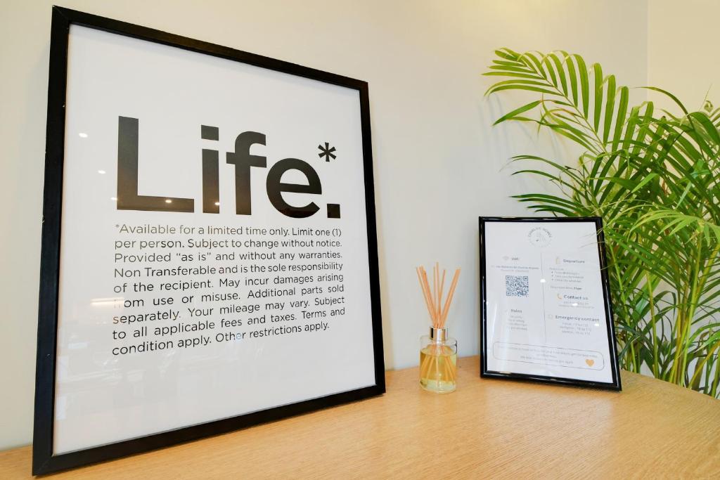 a framed picture sitting on a table next to a sign at Comfy Suite by Les Maisons de Charloc Homes in Boulogne-Billancourt