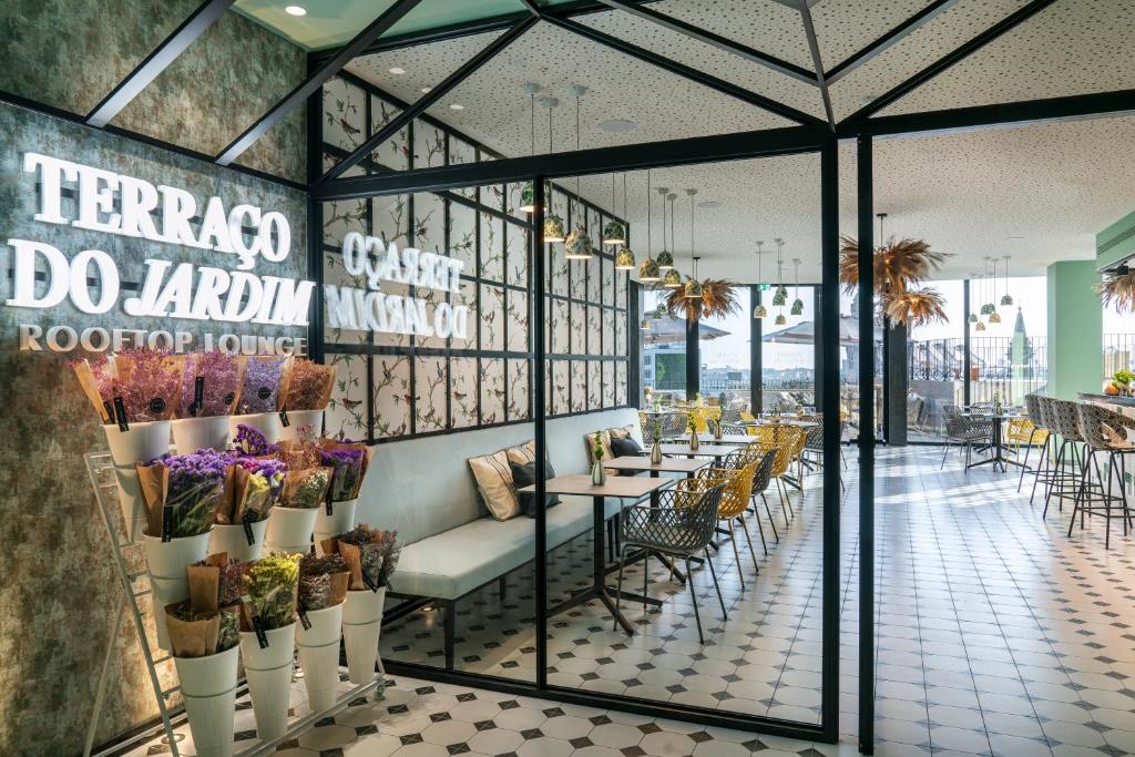 Un restaurante con mesas, sillas y flores. en Vincci Bonjardim, en Oporto