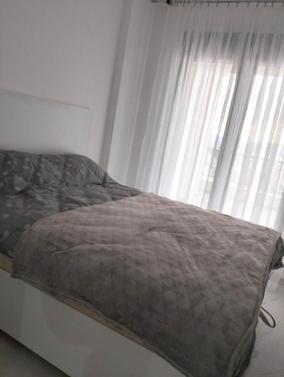 a bed in a room with a window at Tivat Apartman in Tivat