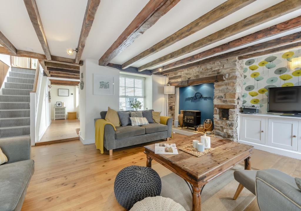 uma sala de estar com um sofá e uma mesa em Ferrymans Cottage em Appledore