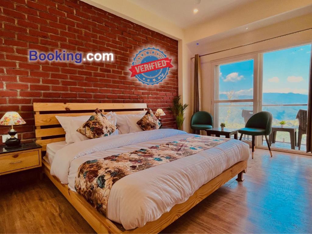 a bedroom with a bed and a brick wall at Hotel Pine Rock Mountain View, Mussoorie in Mussoorie