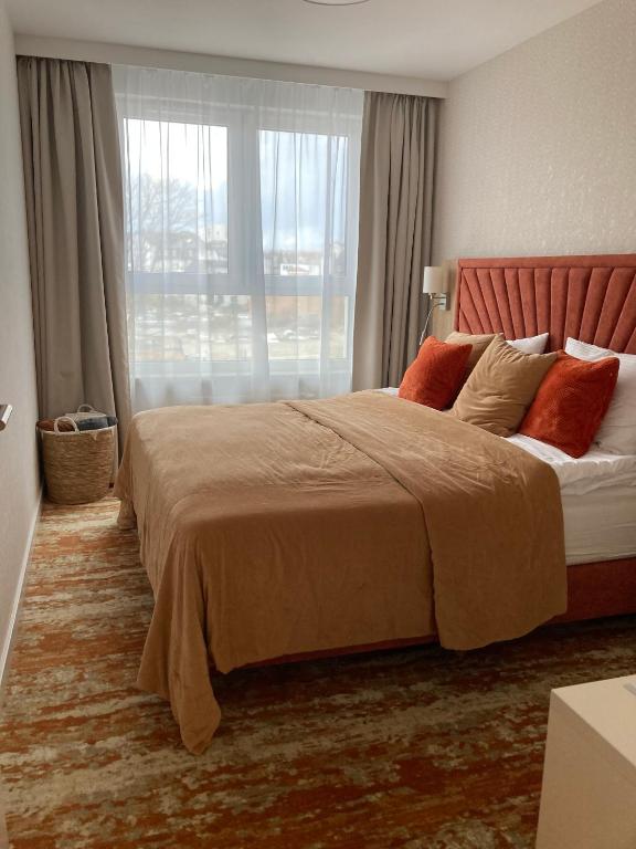 a bedroom with a large bed with a large window at BEL MARE 2 F207 in Międzyzdroje