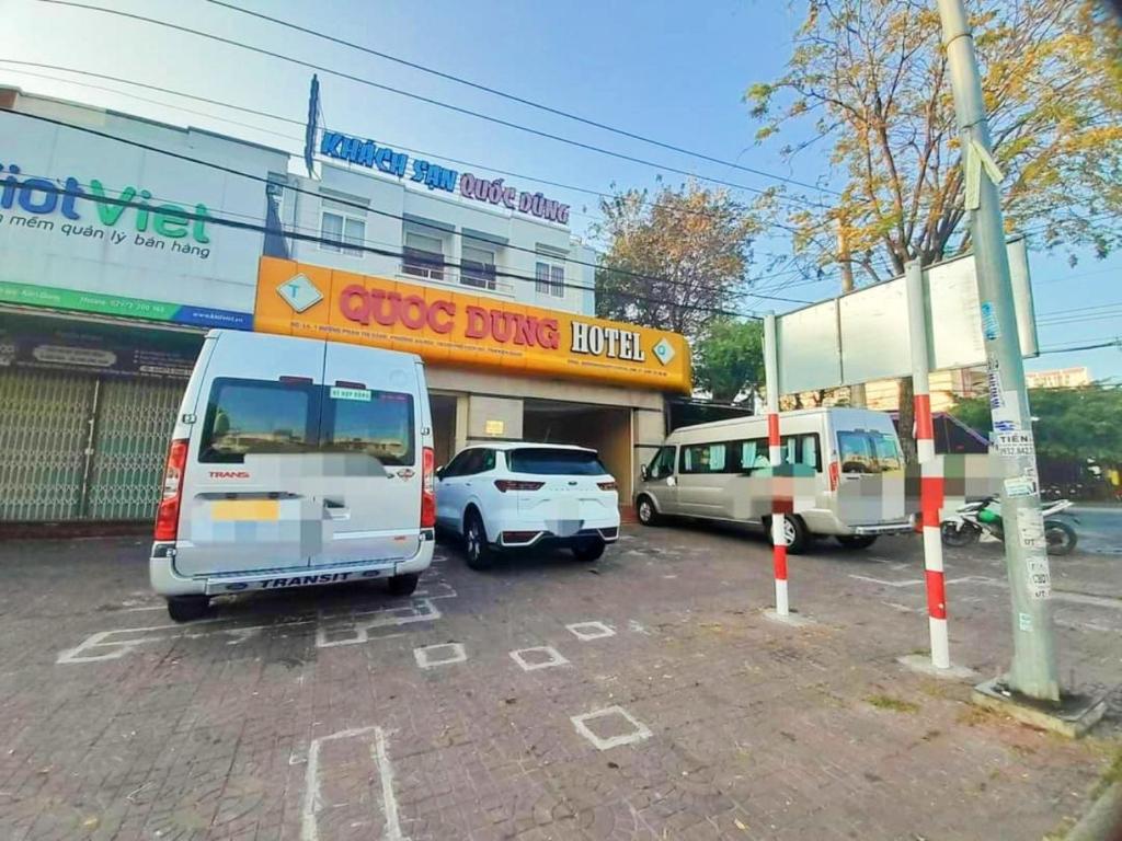 3 auto parcheggiate in un parcheggio di fronte a un negozio di Quoc Dung Hotel a Rach Gia