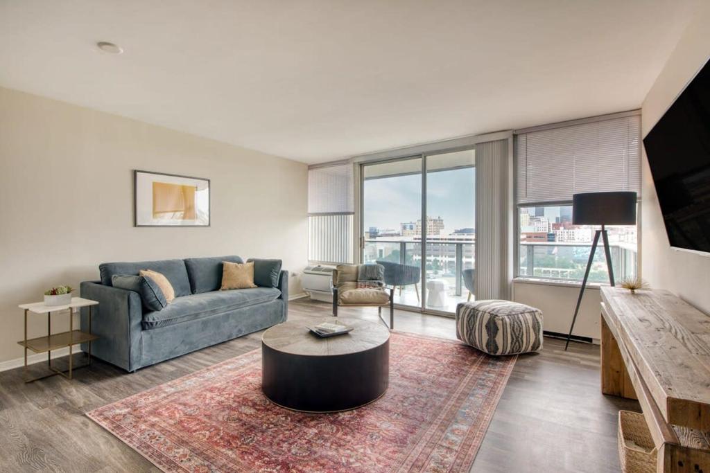 a living room with a couch and a table at CozySuites 800 Tower 1BR w sky pool, gym! 18 in Louisville