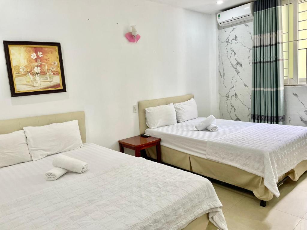 a bedroom with two beds and a window at Ngọc Lan Homestay in Hue