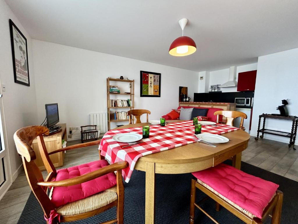 - une table à manger avec un chiffon rouge et blanc dans l'établissement Les Chouettes, au Crotoy