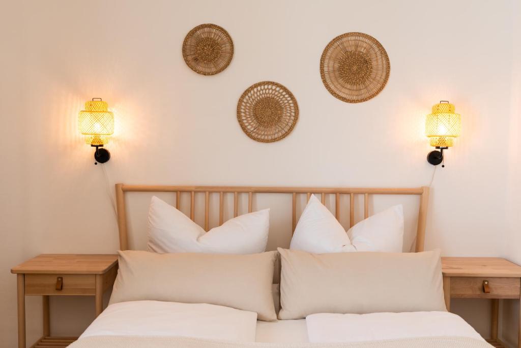 una camera da letto con un letto con cuscini bianchi di Moderne & Familienfreundliche Ferienwohnung am Goitzschesee a Pouch