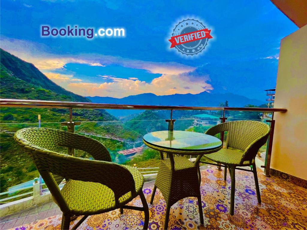 een tafel en stoelen op een balkon met uitzicht bij Hotel Kempty - A Boutique Hotel, Mussoorie in Mussoorie
