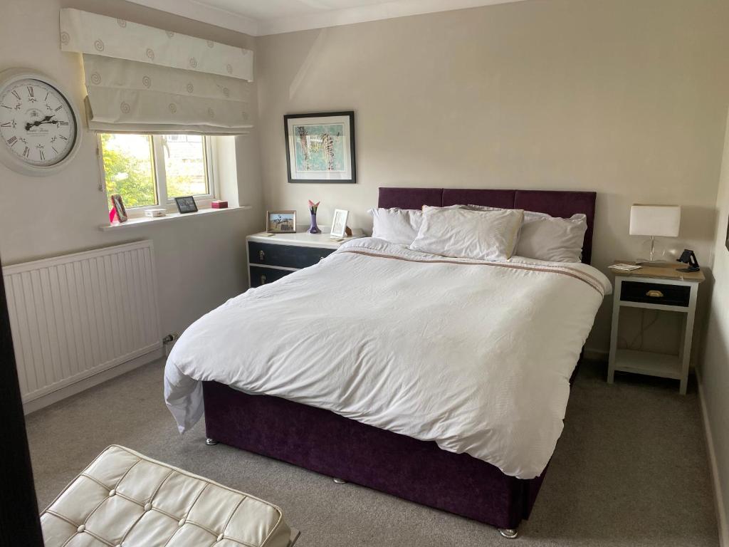 a bedroom with a large bed and a clock on the wall at Stunning 2 bed 2 bath house in Carleton in Pontefract