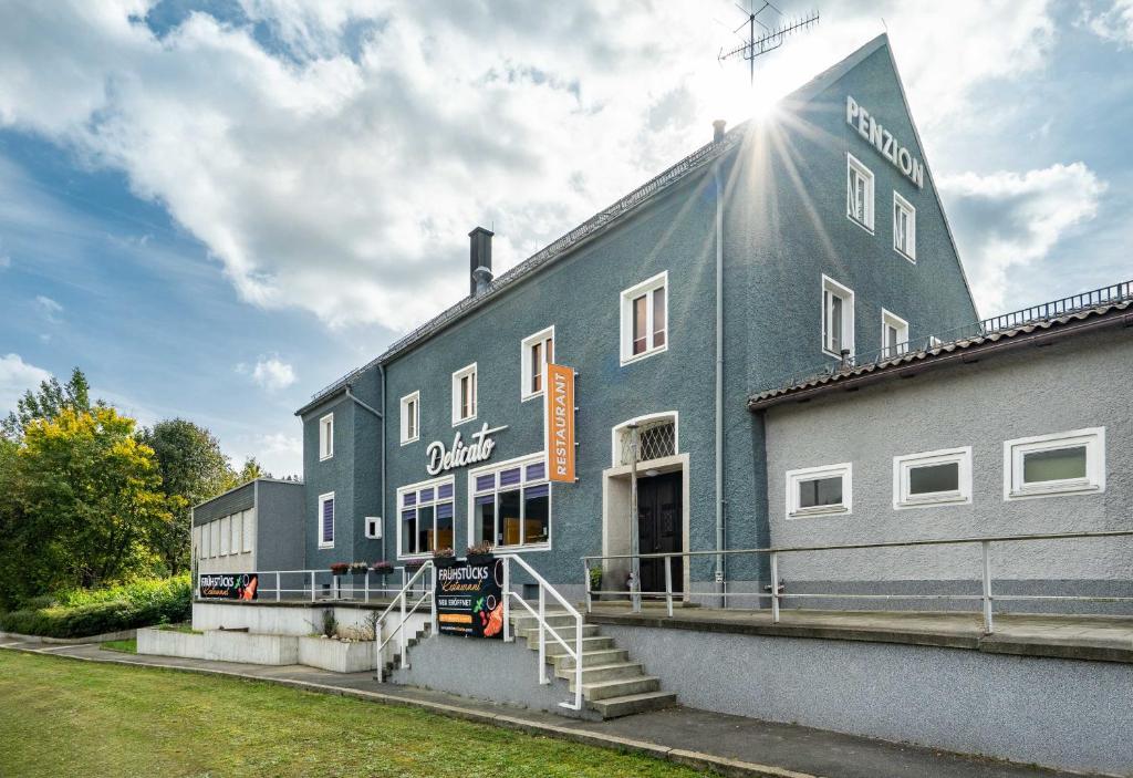 niebieski budynek ze świecącym słońcem w obiekcie Pension Delicato w mieście Waidhaus