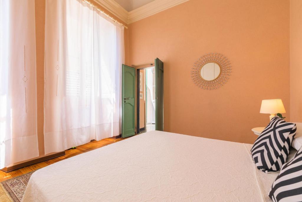 a bedroom with a white bed and a window at Old Town Bonbonniere in Bordighera