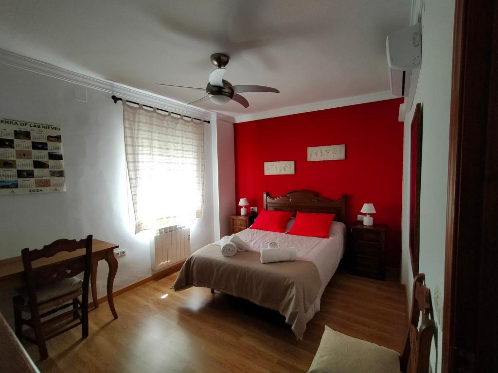 1 dormitorio con paredes rojas y 1 cama con almohadas rojas en Casa / Apartamento Azahar, en Ronda