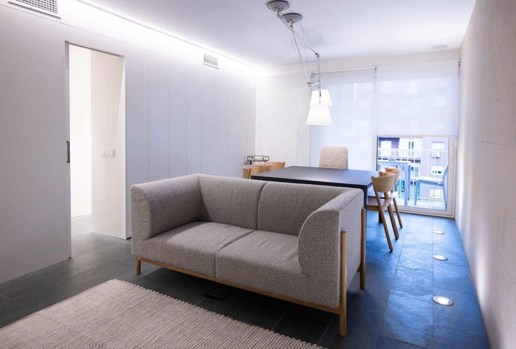 Ampersand - Bright 2-Bedroom Apartment في برشلونة: غرفة معيشة مع أريكة وطاولة