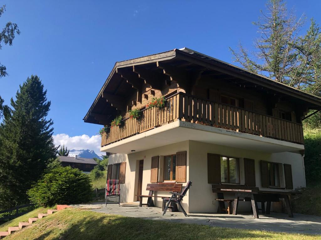 a small house with a balcony and a bench at Chalet Claire in Bürchen