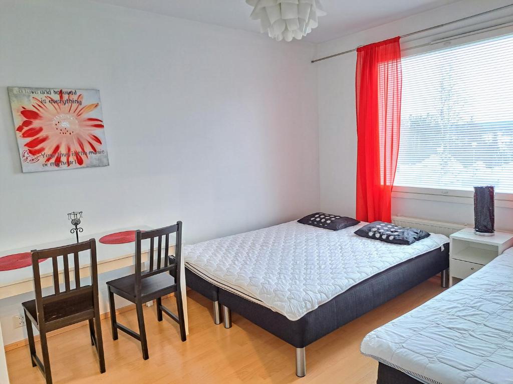1 dormitorio con 1 cama, 2 sillas y ventana en Aurora City Apartment, en Rovaniemi