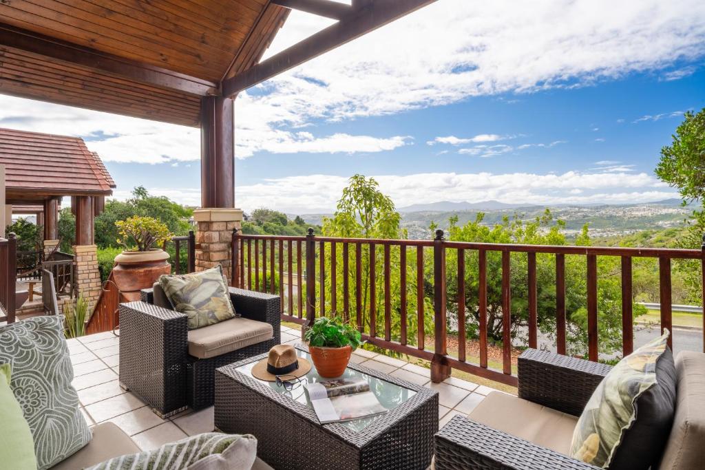 a patio with chairs and a table on a balcony at Luxury , space and views - Pezula Villa 13 in Knysna