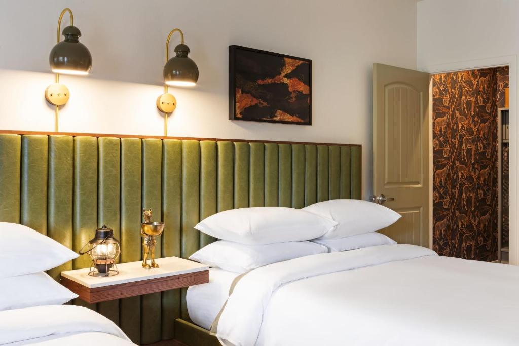 a bedroom with two beds and a green wall at The Red Cliffs Lodge Zion, a Tribute Portfolio Hotel in Springdale