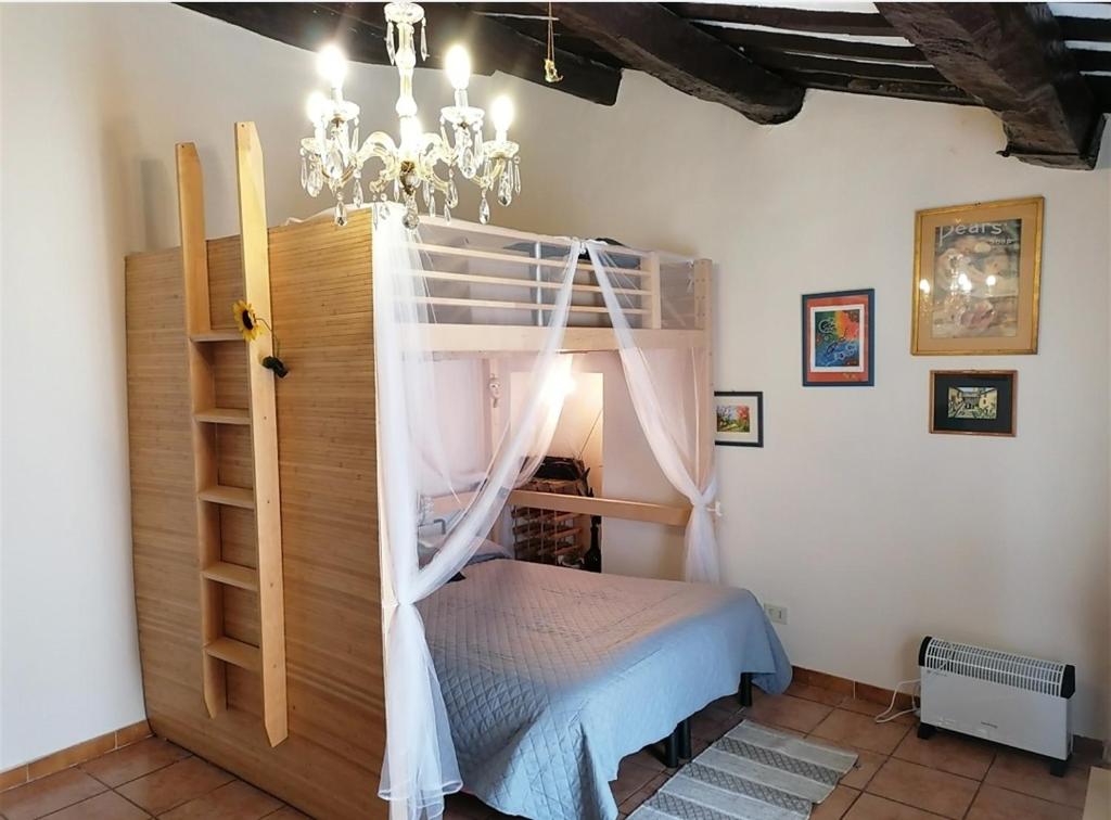 a bedroom with a bunk bed with a chandelier at Casa di Olly - Loft incantevole con camino in Ponticelli