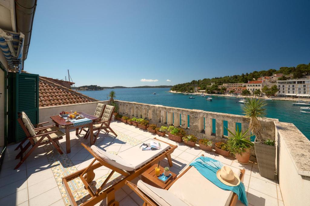 a balcony with a table and chairs and a view of the water at Sun Spalato Fara in Hvar