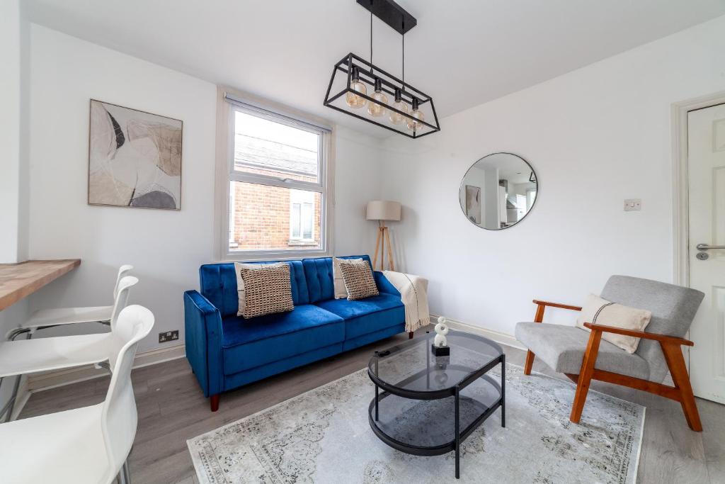 a living room with a blue couch and a table at The Harlesden Villas in London