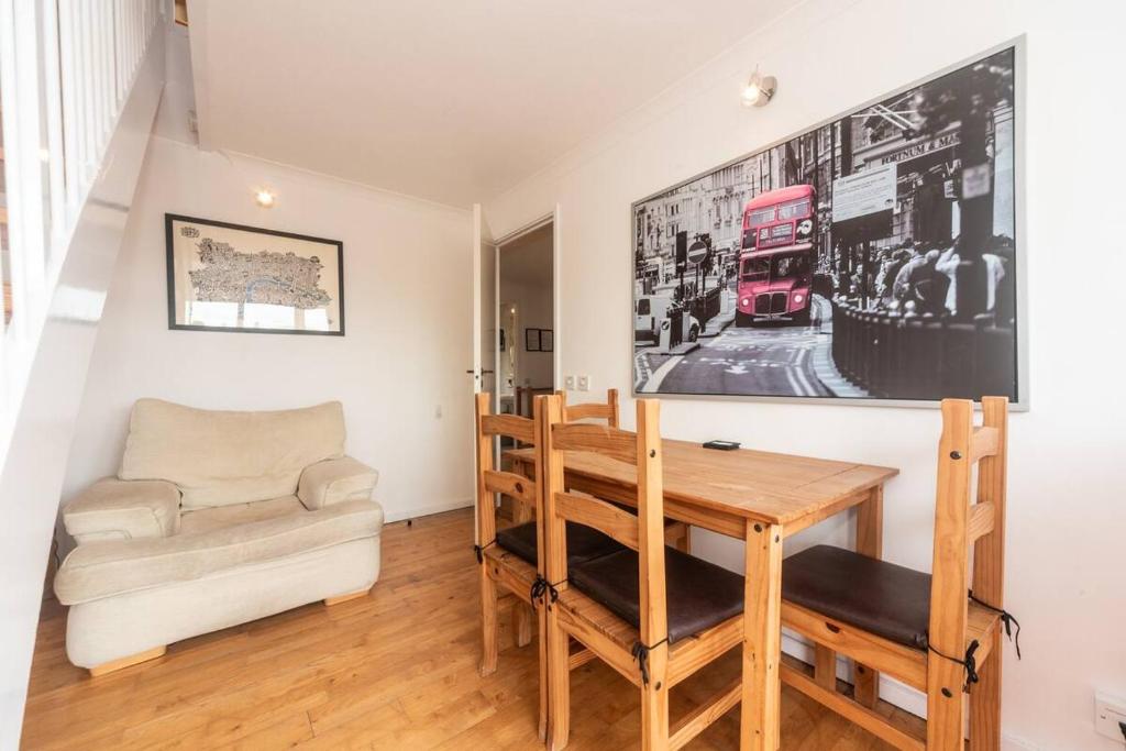 - une salle à manger avec une table et un canapé dans l'établissement Pass the Keys - Sunny flat with Great views over Canary Wharf, London, à Londres