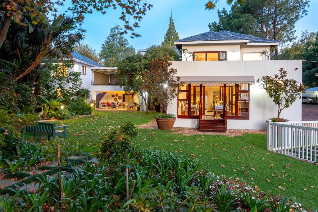 une maison avec une pelouse devant elle dans l'établissement Hyde Park Guest House, à Johannesbourg