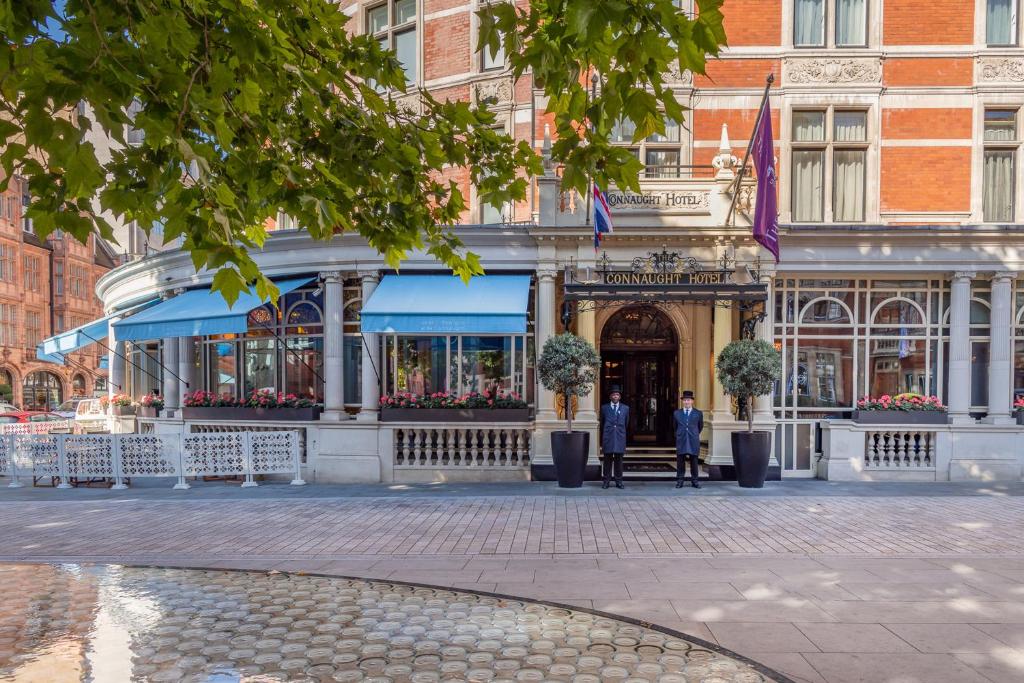 duas pessoas em frente a um edifício em The Connaught em Londres