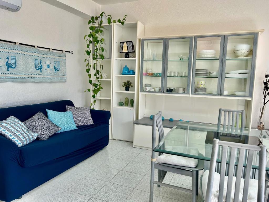 sala de estar con sofá azul y mesa de cristal en Sea View Apartment, en Cardedu