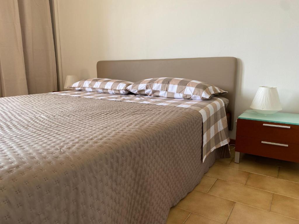 1 cama con 2 almohadas y mesita de noche en Appartamento 44, en Novara
