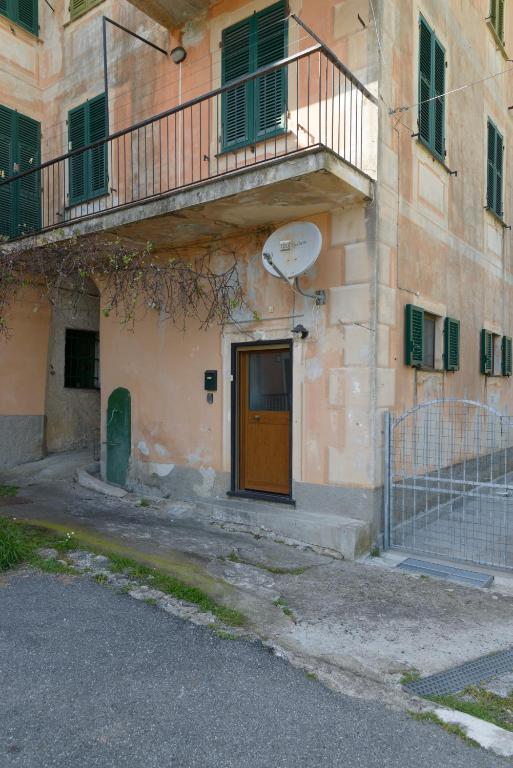 a building with a yellow door and a balcony at Fattore 8 in Levanto