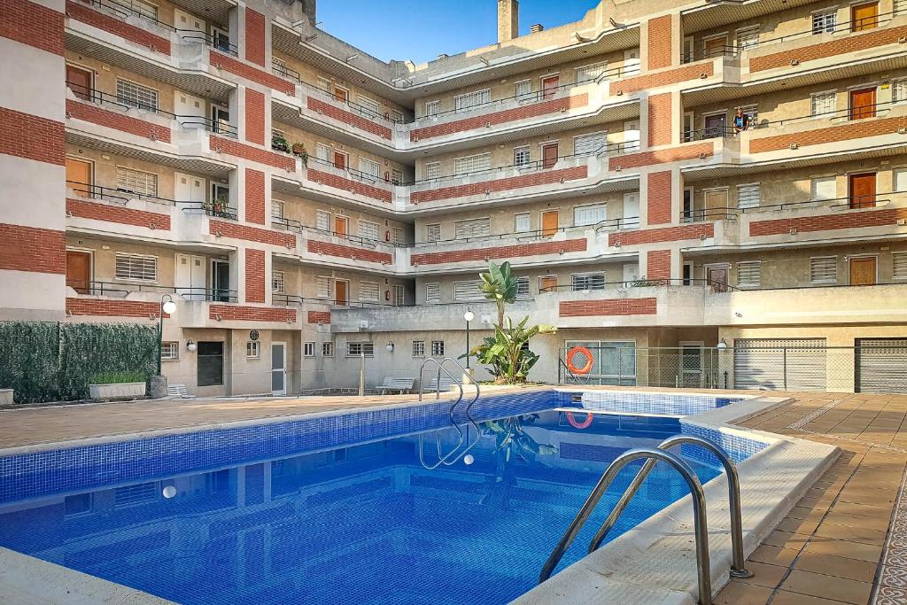 a swimming pool in front of a building at AT097 Torrepark in Torredembarra