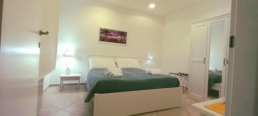 een slaapkamer met een bed met een groene deken bij Miriam Casa Vacanze in Flumini di Quartu