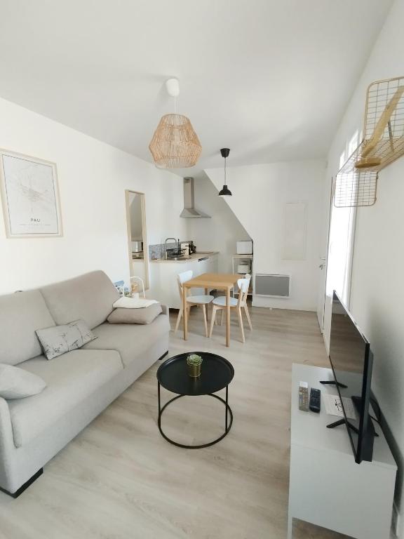 un salon blanc avec un canapé et une table dans l'établissement Stylish Nest: studio tout confort au cœur de Pau, à Pau